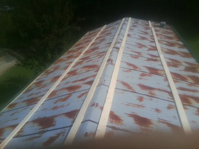Rusted metal roof panels with new wood purlins before replacement — Storm Damage Roof Repair in Hill by Roofing Brothers