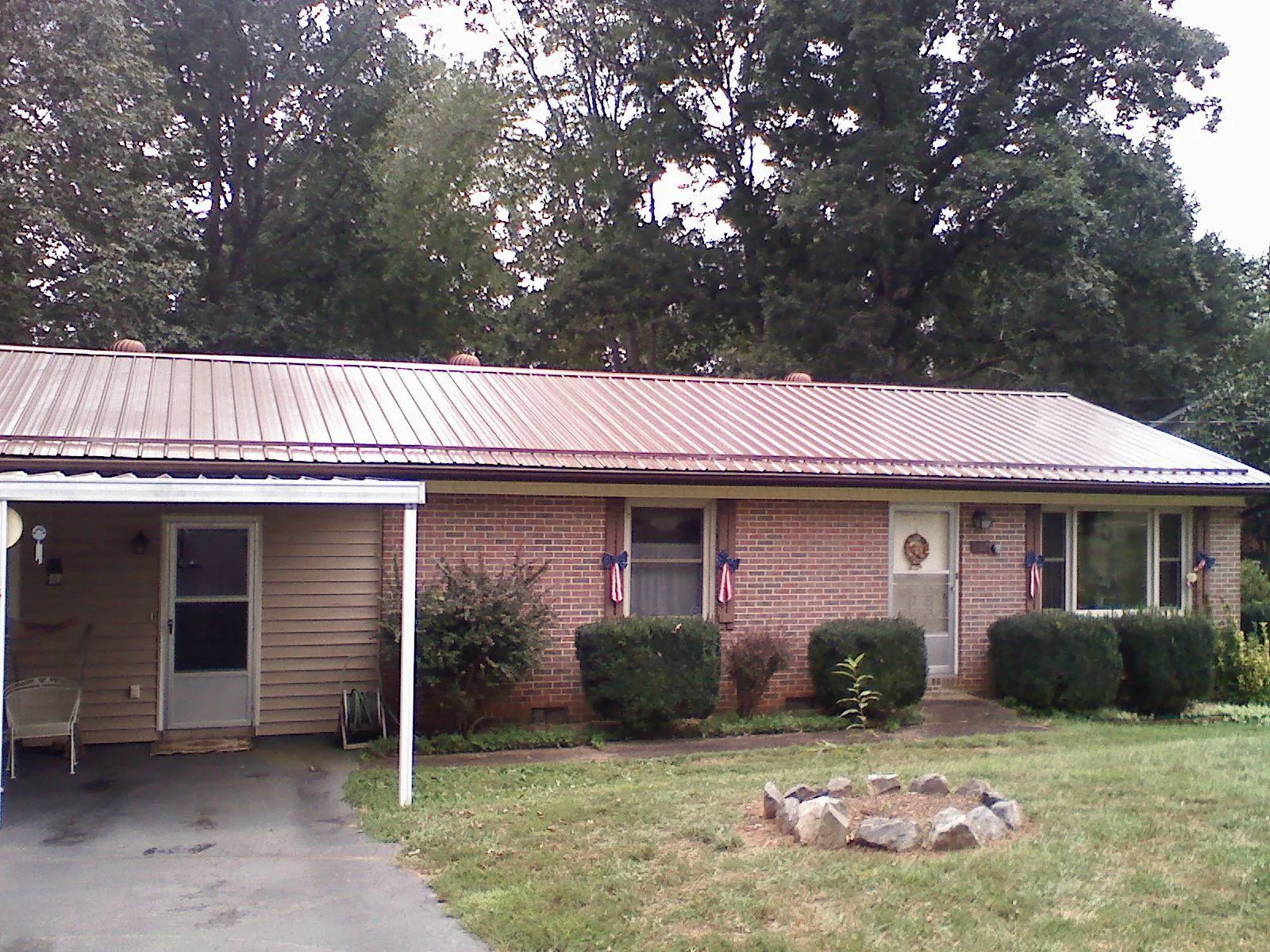 Bronze metal roof and carport on a brick ranch home — Roof Repair work by our crew in Hill