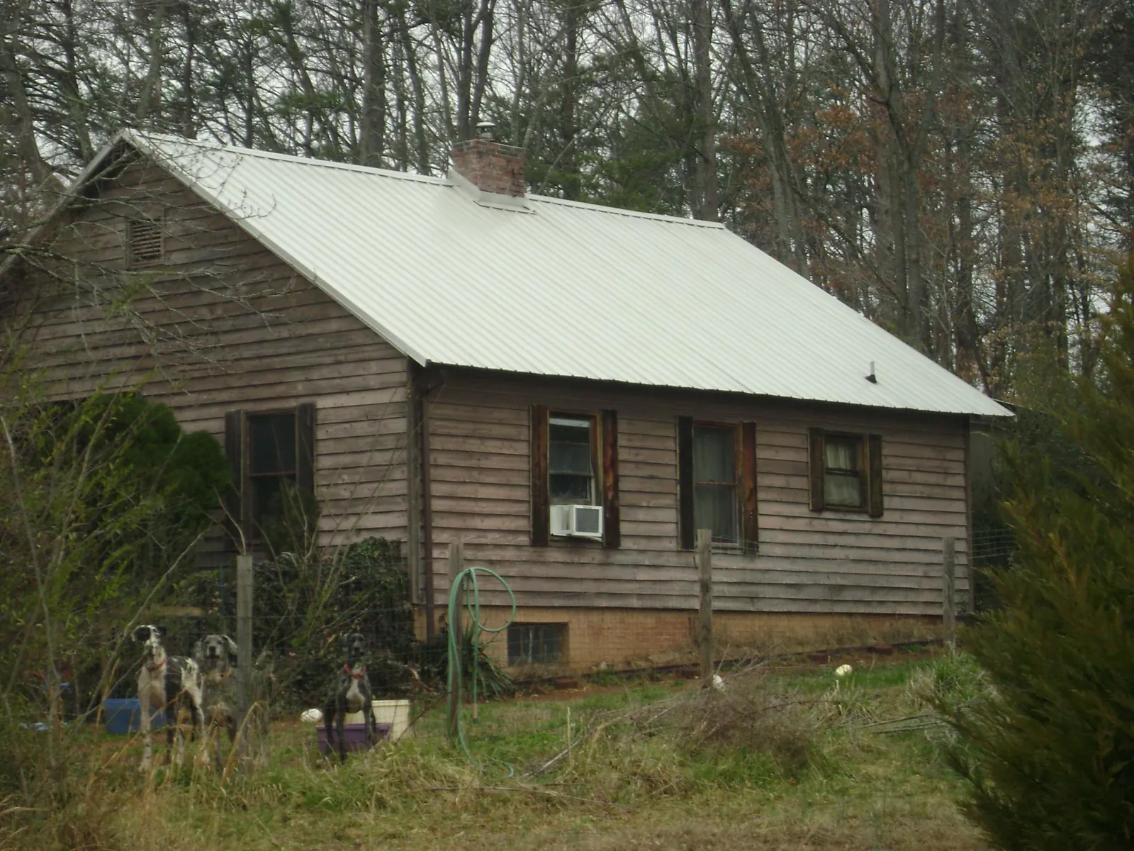White metal roof on an old wood sided farmhouse, from a Metal Roof Installation job in Hill